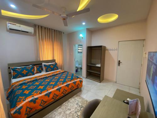 阿布贾C7 Hazelwood Residence & Suites的一间卧室配有一张床和一台电视。