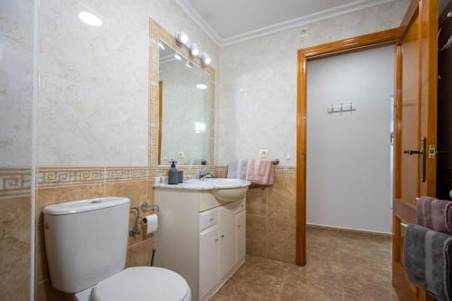 坎波阿莫Playamarina II in Cabo Roig的一间带卫生间、水槽和镜子的浴室