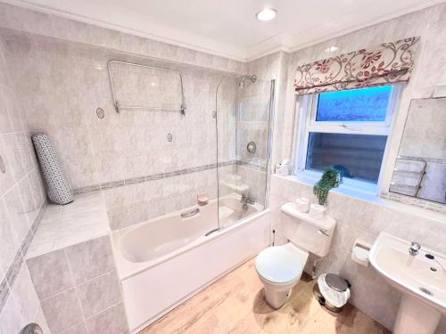 利明顿帕斯福德豪斯酒店的带浴缸、卫生间和盥洗盆的浴室
