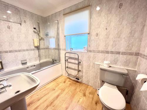 利明顿帕斯福德豪斯酒店的浴室配有卫生间、盥洗盆和浴缸。