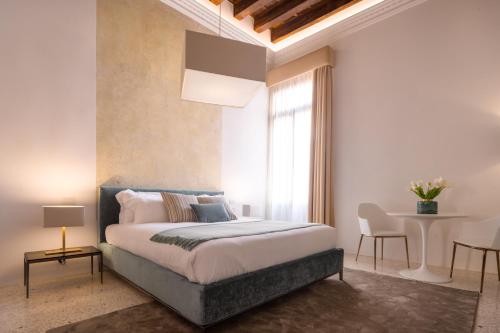 威尼斯Ninfea Luxury Suites的一间卧室设有一张大床和一个窗户。
