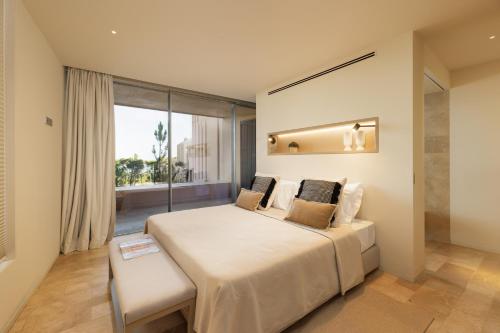 拉戈斯Palmares Signature Apartments的一间卧室设有一张大床和一个窗户。