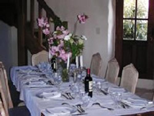 Maison de 5 chambres avec jardin clos et wifi a Morannes sur Sarthe的长桌,带玻璃杯和一瓶葡萄酒