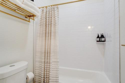 史普林维尔Suite 1 Historic Art City Inn的白色的浴室设有淋浴帘和卫生间。