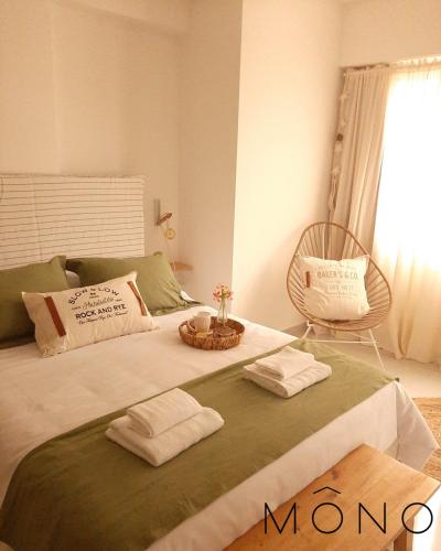 内乌肯Mono Neuquen的一间卧室配有一张床,上面有两条毛巾