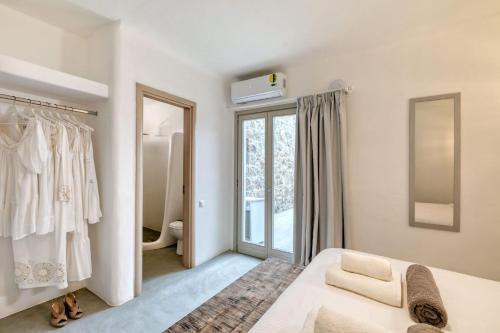 帕诺尔莫斯米科诺斯Elegant Mykonos Villa Air Private Pool 4 Bedrooms Sea View Panormos的白色的卧室设有床和窗户