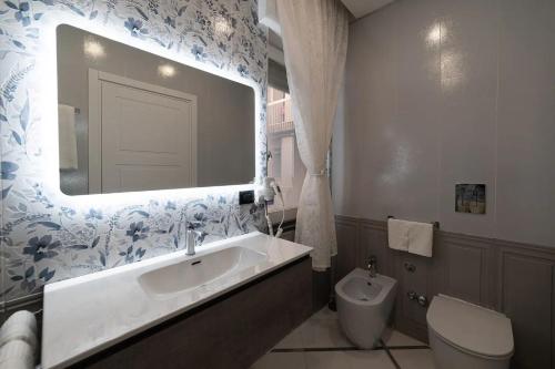 那不勒斯Apartments Hotel Real Suite Napoli Chiaia Mergellina的一间带水槽、卫生间和镜子的浴室