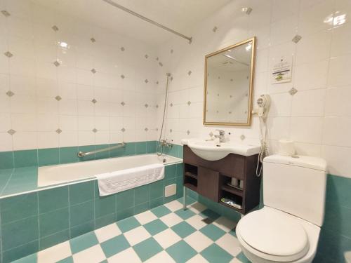 台南文化信然的浴室配有卫生间、盥洗盆和浴缸。