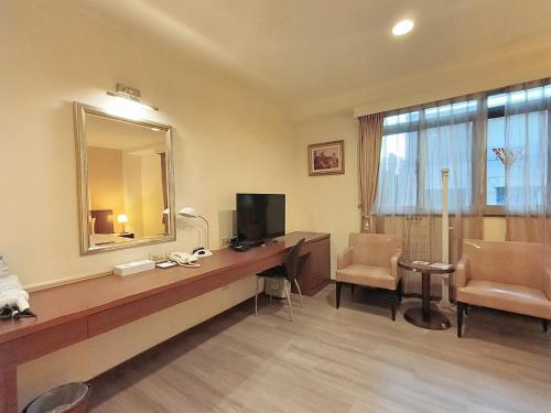 台南文化信然的酒店客房配有带电视和镜子的书桌