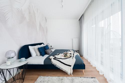 米科瓦伊基Lake Club Apartments by LoftAffair的一间卧室设有蓝色的床和白色的墙壁