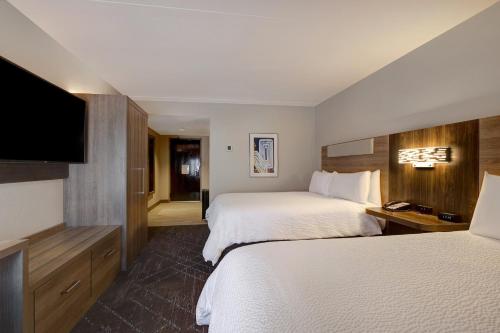 堪萨斯城堪萨斯城KU医疗中心智选假日酒店及套房的酒店客房设有两张床和一台平面电视。