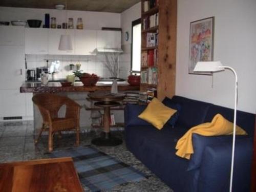 加维科利亚诺Casa Cresmino的一间带蓝色沙发的客厅和一间厨房