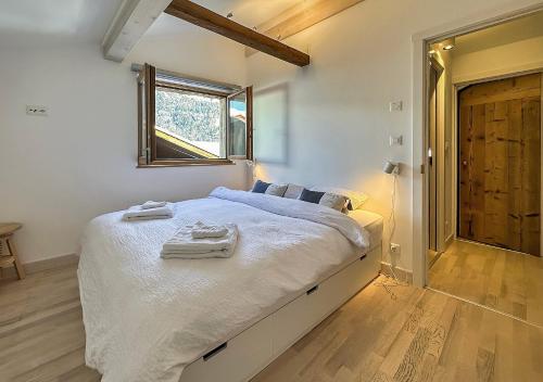 BrusonMon Raccard Cosy - 4 vallées的一间卧室配有一张床,上面有两条毛巾