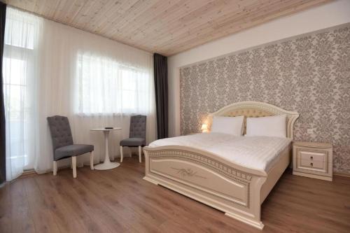 斯文托伊Floros simfonija Jūros的卧室配有白色的床和桌椅