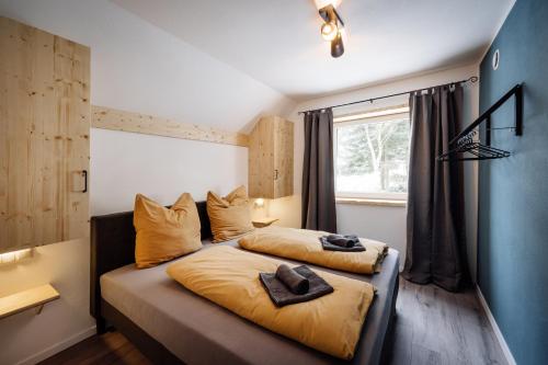 比特亨巴赫Urlaub am Schwarzbach mit Sauna und Whilpool的一间卧室,配有一张带两顶帽子的床