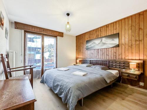 韦尔比耶Instant sports & ski Paradise的一间卧室设有一张带木墙的大床