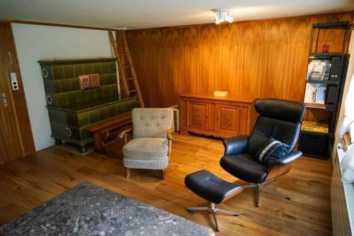 因内特基尔兴4-Bett- Ferienwohnung Brachli的客厅配有2把椅子和书桌