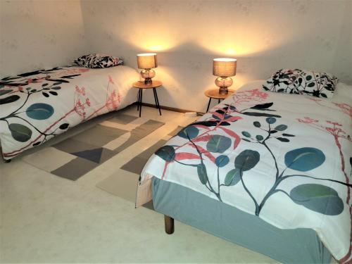 NärpiöBest possible location, 1 bedroom apartment的配有两张床铺的房间,桌子上放着两盏灯