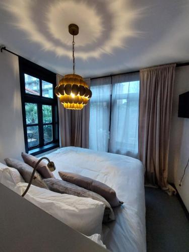 阿默斯福特Saya Boutique Hotel的卧室配有一张白色大床和吊灯。