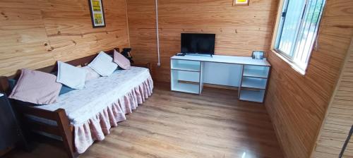 萨利纳斯Casita con vista al mar的客房设有床、书桌和电视。