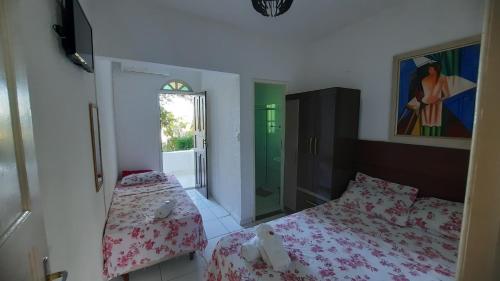 瓜拉派瑞Pousada Casa Verde的一间小卧室,配有两张床和窗户
