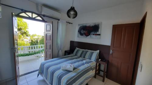瓜拉派瑞Pousada Casa Verde的一间卧室设有一张床和一个阳台