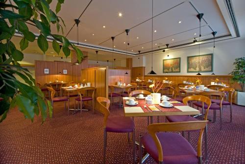 哥廷根雷纳酒店的餐厅设有木桌和紫色椅子