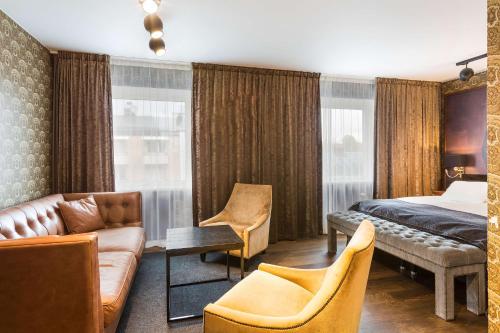 维默比Vimmerby Stadshotell, WorldHotels Crafted的酒店客房,配有床和沙发