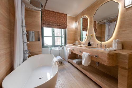 姆迪纳Palazzo Bifora的一间带浴缸和大镜子的浴室