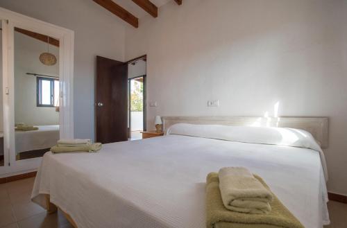 拉萨维纳APARTAMENTOS CASA EUGENIO FORMENTERA的卧室配有白色床和毛巾