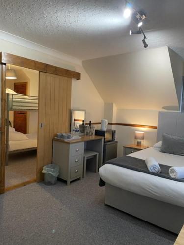 威廉堡Highland Stays - Rushfield House Rooms的酒店客房带一张床铺、一张书桌和一间卧室