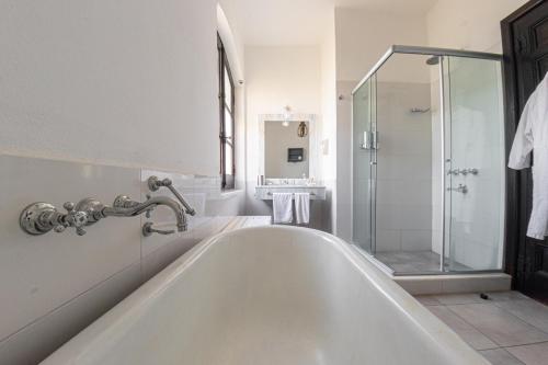 上格拉西亚Hotel El Potrerillo de Larreta的带淋浴的浴室配有白色浴缸。