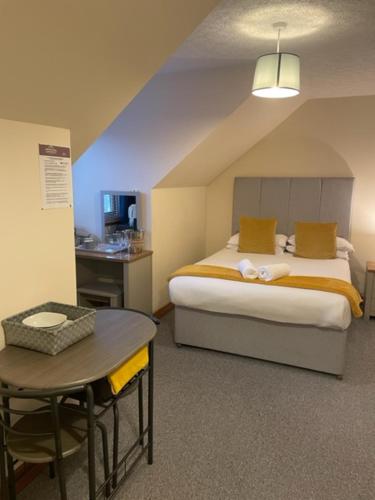 威廉堡Highland Stays - Rushfield House Rooms的一间卧室配有一张床、一张桌子和一张桌子