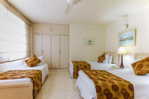 巴兰卡韦梅哈Hotel San Carlos的一间酒店客房,房间内设有三张床