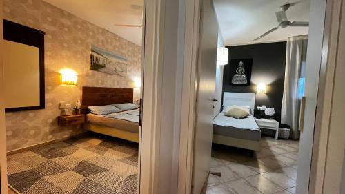 圣玛丽亚Tropical Morabeza Apartment Santa Maria的一间小房间,设有两张床和走廊