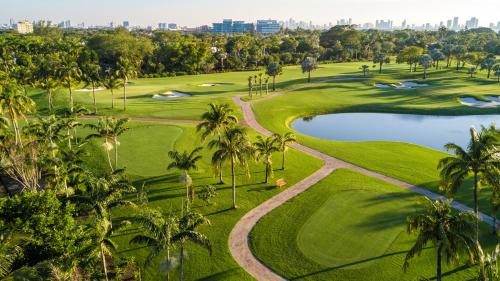 迈阿密海滩Luxurious Private Condo at 1 Hotel & Homes -1045的享有棕榈树和池塘的高尔夫球场的空中景致