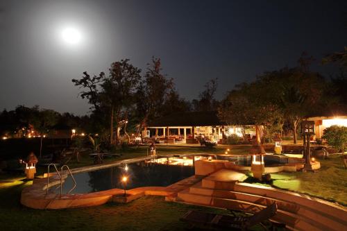 Dhanwār图里老虎度假村的夜晚的泳池与天空中的月亮
