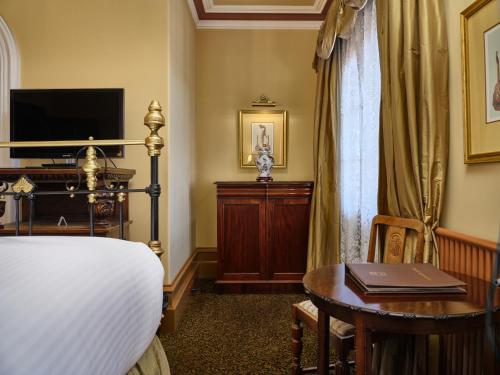 巴拉腊特克雷格皇家酒店的一间卧室配有一张床、一张书桌和一台电视