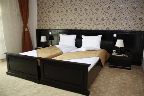 苏恰瓦帝国酒店的卧室配有带白色枕头的大床