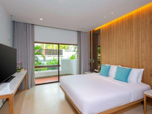 港生Novotel Rayong Rim Pae Resort的卧室配有一张白色大床和电视。