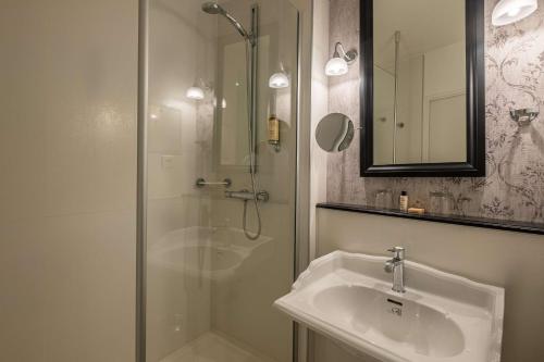 鲁昂Hôtel Littéraire Gustave Flaubert, BW Signature Collection的带淋浴、盥洗盆和镜子的浴室