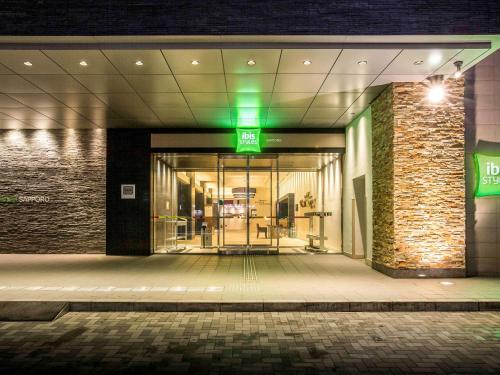 札幌札幌宜必思尚品酒店的夜间进入绿灯的建筑物