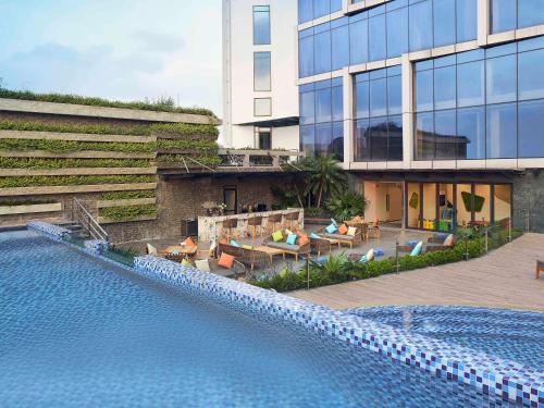 河内Novotel Hanoi Thai Ha的大楼前设有游泳池的酒店