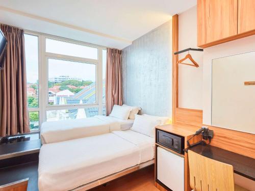 新加坡ibis budget Singapore West Coast的酒店客房设有两张床和大窗户。