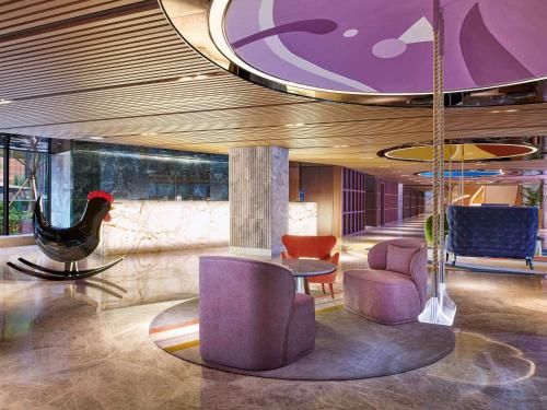 首尔蒙德里安首尔梨泰院街酒店的大堂配有紫色家具和桌椅
