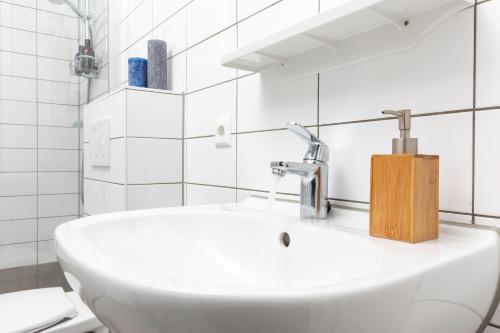 代尔夫特City Center Family Apartment Balcony open View Delft的浴室铺有白色瓷砖,配有白色水槽。