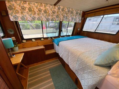 SavannaThe Lily Pad Boatel Houseboat的船上的卧室,带床和窗户
