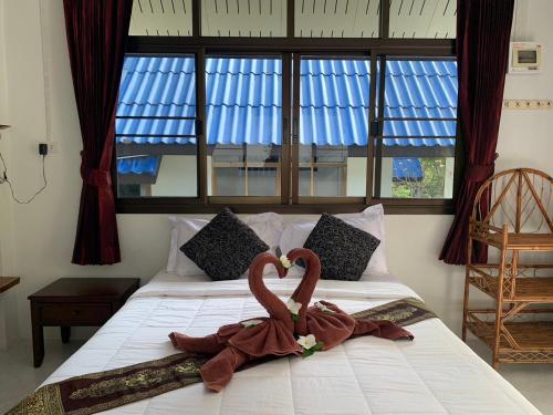 俊穆岛Koh Jum Serenity Resort的卧室里床边的两只天鹅