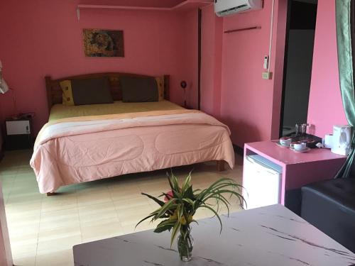 象岛Grand Tree的粉红色客房内的一间卧室,配有一张床