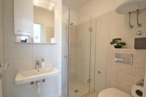 伯德古拉Apartments Maja 100 from the beach的一间带水槽和玻璃淋浴的浴室